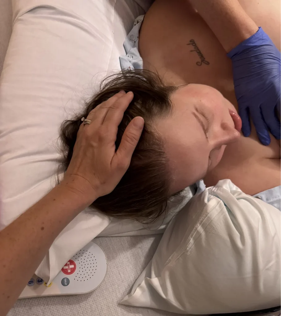A hand gently stroking the hair of a person resting on a pillow