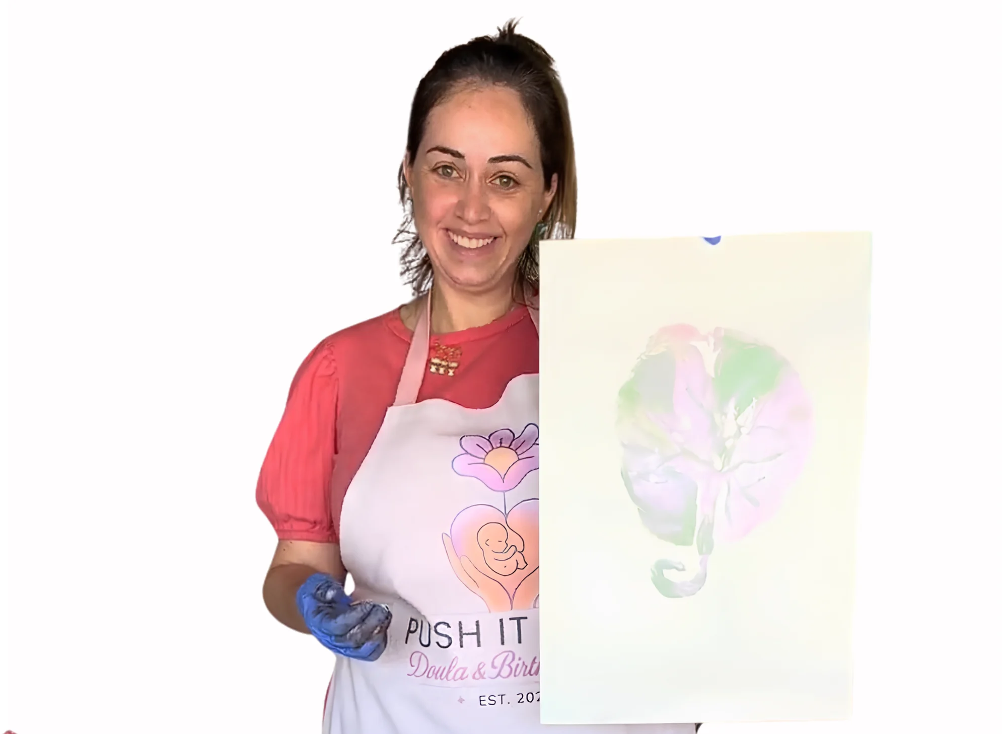 A smiling woman in an apron holding a placenta print on paper